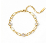Gold chain bracelet with three diamond-like stones on a white background