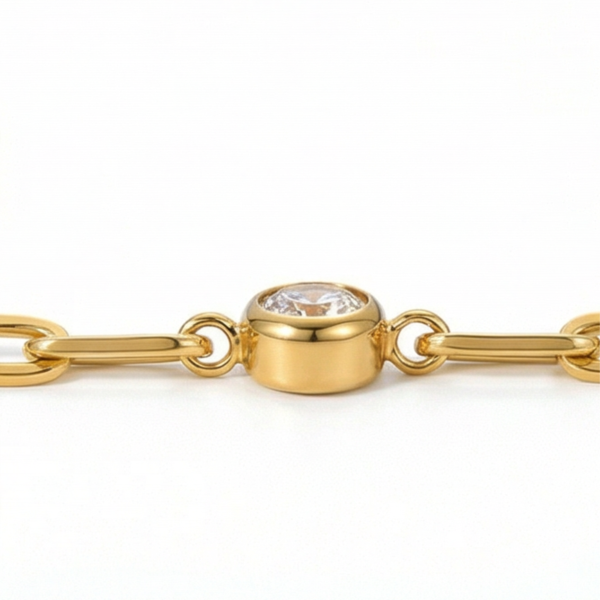 Close up of white gemstone on a gold chain bracelet on a white background