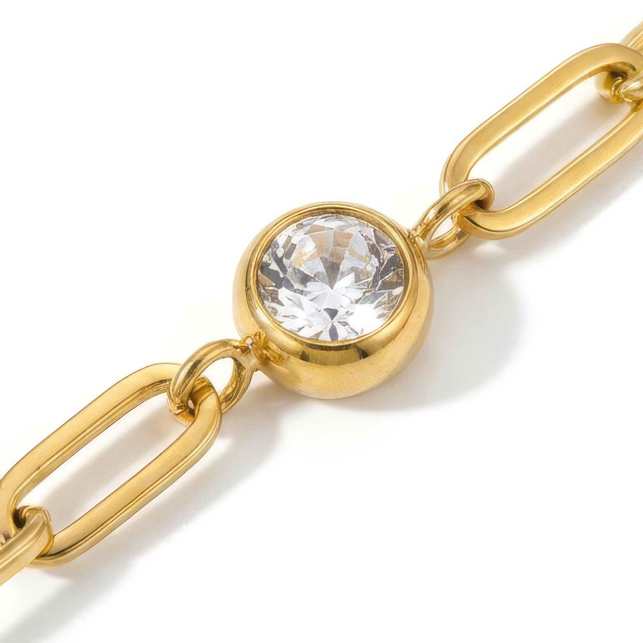 Close up of white gemstone on a gold chain bracelet on a white background