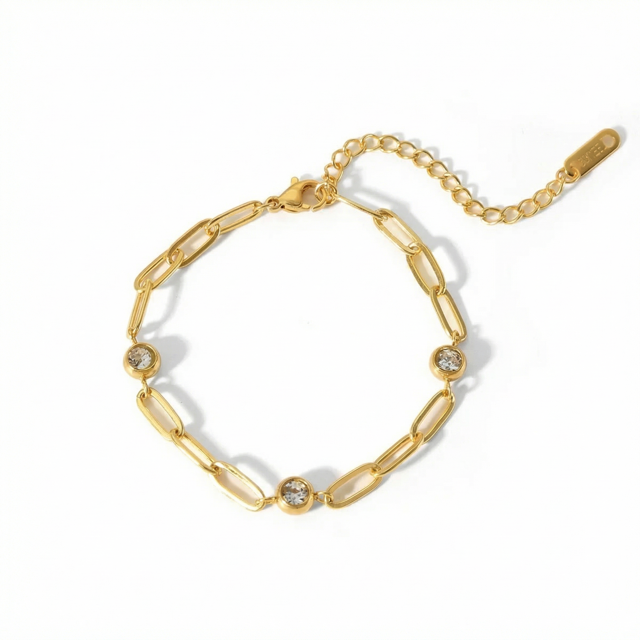 Gold chain bracelet with diamond-like stones on a white background