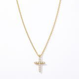 The Glory'd Signature Cross Necklace which is a yellow gold cross pendant necklace adorned with clear round-cut gemstones, suspended from a matching gold chain against a plain white background.