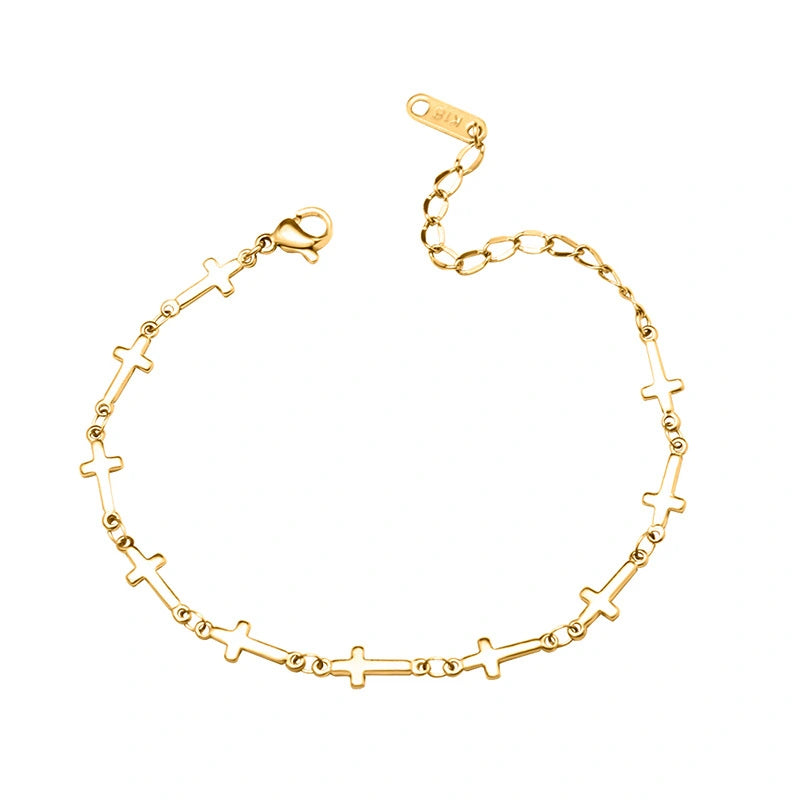 Gold bracelet with links made of mini crosses on a white background