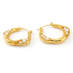 Gold hoop earrings with pearl accents on a white background