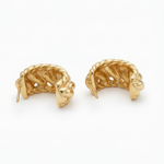 Pair of gold leaf-shaped earrings on a white background
