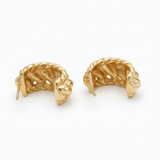 Pair of gold leaf-shaped earrings on a white background
