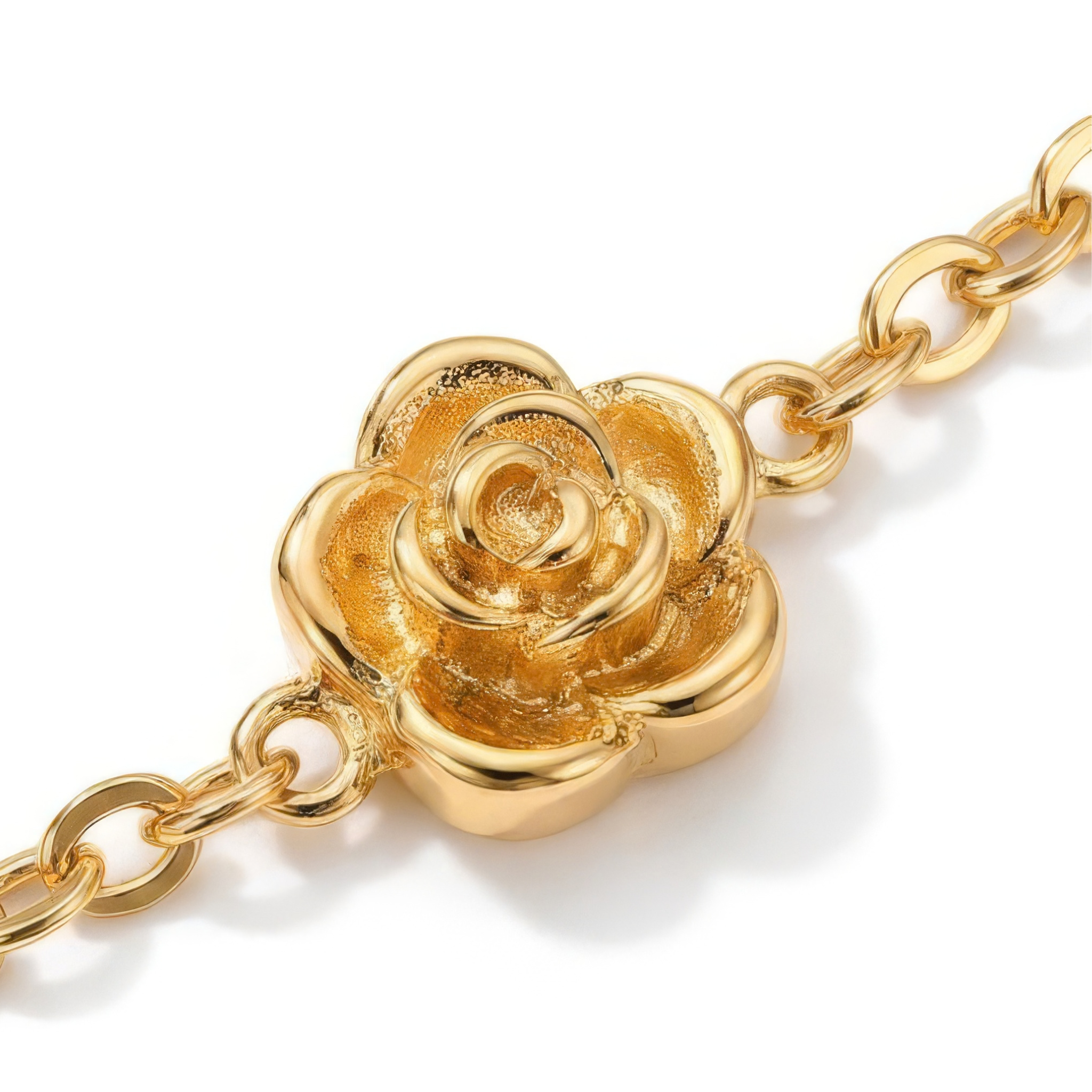 Close up of stationary gold rosebud design on a gold bracelet on a white background