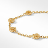 Close up of gold bracelet with stationary gold rosebud designs spaced out on the chain on a white background